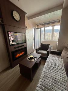 a living room with a fireplace and a tv at La Montaña apartman in Zlatibor