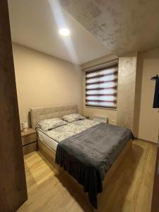 a bedroom with a bed and a window at La Montaña apartman in Zlatibor