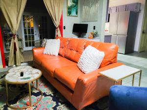 A Bliss of Color Townhouse في جاكسون: أريكة من الجلد البرتقالي في غرفة المعيشة