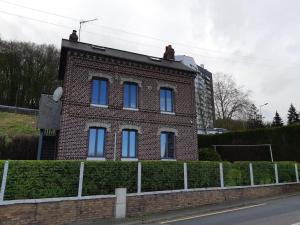 a brick building with blue windows on a street at La briqueterie de Maromme in Maromme