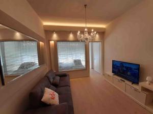 a living room with a couch and a flat screen tv at Sea View Apartment with Veranda Beach Amazing in Vlorë