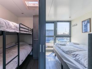 two bunk beds in a room with a window at Tiny houseboat Uitgeest I in Uitgeest