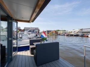 a dock with a table and chairs on a boat at Tiny houseboat Uitgeest I in Uitgeest