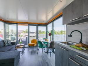 a kitchen and living room with a view of the water at Tiny houseboat Uitgeest I in Uitgeest