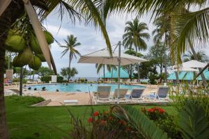 a swimming pool with chairs and an umbrella at Atami Escape Resort in La Libertad