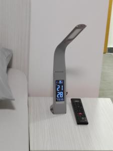 a alarm clock sitting on a table next to a remote control at Apartman Iris in Vrnjačka Banja