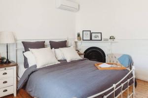 een slaapkamer met een groot bed en een open haard bij Hargreaves Cottage - close to CBD in Bendigo