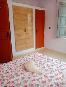 a white animal laying on a bed in a bedroom at Villa for daily rent فيلا للكراء اليومي in Marrakesh