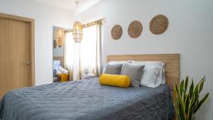 a bedroom with a bed with a yellow pillow on it at Coco Surf Tropical Village in La Libertad +35 photos