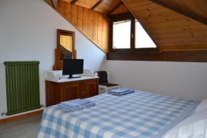 a room with a bed and a television in a attic at Dimaro Folgarida Appartamento trilocale in villa in Monclassico
