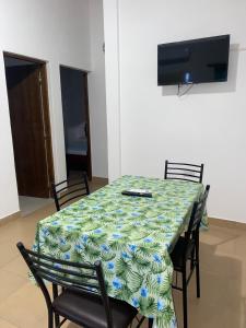 mesa de comedor con sillas y TV en la pared en Cabañas La Heredera en Salta