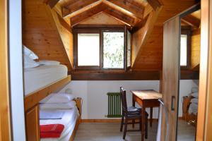 a room with two bunk beds and a desk in a cabin at Dimaro Folgarida Appartamento trilocale in villa in Monclassico