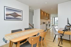 a kitchen and dining room with a wooden table and chairs at Worcester Terrace One - Christchurch Holiday Homes in Christchurch