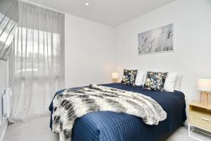 a bedroom with a blue bed and a window at Worcester Terrace One - Christchurch Holiday Homes in Christchurch