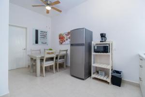 uma cozinha com um frigorífico e uma mesa com um micro-ondas em Tonacalli, departamentos privados con alberca em San Carlos