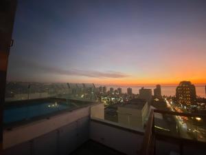 a view of the city at sunset from the rooftop of a building at Departamento viña del mar in Viña del Mar