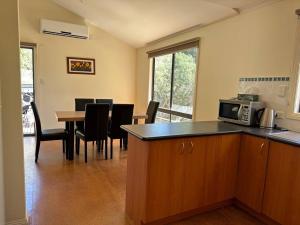 una cucina e una sala da pranzo con tavolo e forno a microonde di Bliss in Venus Bay - Welcome to 2025! a Venus Bay Altre 15 foto