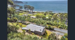 an aerial view of a house and the ocean at Elevated 3BR, ocean views, pool table, Pirates Bay in Eaglehawk Neck