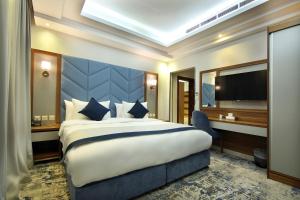 une chambre d'hôtel avec un grand lit et une télévision dans l'établissement لاريتشي جدة للشقق المخدومة, à Djeddah
