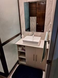 a bathroom with a sink and a mirror at Stunning Two-Bedroom: Perfect Home Away from Home in Suva