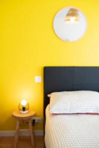 a bedroom with a bed and a table with a light at MLA Homes - Sunny Foller in Nancy
