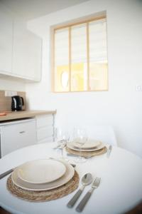 a white table with plates and silverware on it at MLA Homes - Sunny Foller in Nancy