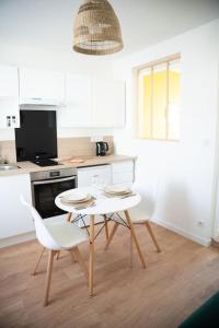 a kitchen with a table and two chairs in it at MLA Homes - Sunny Foller in Nancy