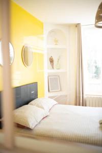 a bedroom with a bed with yellow walls and a window at MLA Homes - Sunny Foller in Nancy