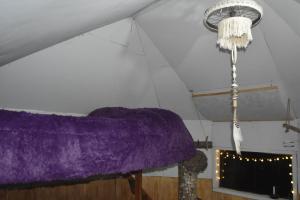 a purple blanket hanging from a ceiling with a chandelier at Refugio El Cauque in Puerto Williams