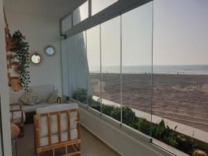 um quarto com uma grande janela com vista para a praia em vue panoramique front mer em Casablanca