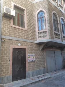 a brick building with a black door and two windows at BAKU GUEST HOSTEL in Baku