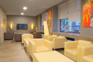 a waiting room with yellow chairs and a television at Rias Bajas in Pontevedra