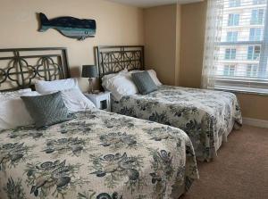 um quarto com duas camas e um peixe na parede em Opus Condominiums em Daytona Beach Shores