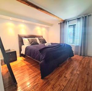 a bedroom with a large bed and a wooden floor at Gîte du Pionnier in L'islet Sur Mer