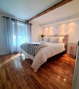 ein Schlafzimmer mit einem großen Bett und einem großen Fenster in der Unterkunft Gîte du Pionnier in L'islet Sur Mer