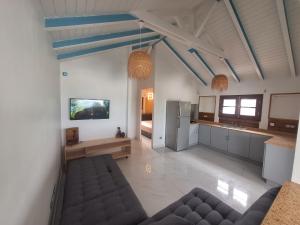 uma sala de estar com um sofá e uma cozinha em RIVER PARADISE em Goyave