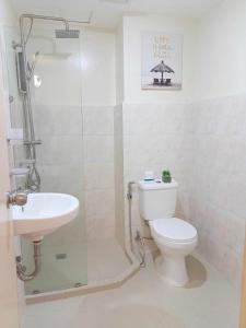 a bathroom with a toilet and a sink at PacificSuites PH in Dasag