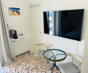 サヴェッレトリにあるSavelletri Miramareの椅子2脚、テーブル、テレビが備わる客室です。