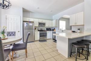 - une cuisine avec des placards blancs, une table et des chaises dans l'établissement Christophers Windsor Hills Home, à Orlando
