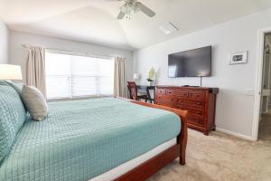 - une chambre avec un lit, une commode et une télévision dans l'établissement Christophers Windsor Hills Home, à Orlando