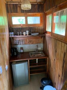 a small kitchen with a sink in a wooden cabin at Tiny Houses Unique Tayrona - Dentro del Parque Tayrona in El Zaino