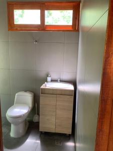 a bathroom with a toilet and a sink and a window at Tiny Houses Unique Tayrona - Dentro del Parque Tayrona in El Zaino