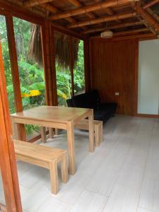 uma mesa de madeira e bancos num quarto em Tiny Houses Unique Tayrona - Dentro del Parque Tayrona em El Zaino