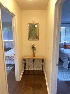 a hallway with a table with a plant on it at THE MANONO HOUSE - Peaceful, Private 3Bd 2Bath Home near HILO, with AC! in Keaau