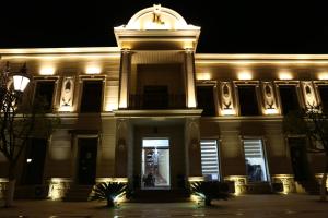a building with a clock tower at night at Luxe Lankaran Hotel in Lankaran