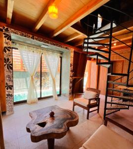 a living room with a table and a spiral staircase at A&V Hotel Boutique in Acapulco