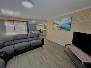a living room with a couch and a flat screen tv at Breakaway Esperance in Esperance