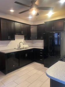 a kitchen with black cabinets and a black refrigerator at Cool and affordable apartment Galesburg in Galesburg