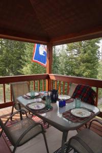 a table and chairs on a screened porch with a table and chairs at Beautiful Mountain Cabin near Tetons Yellowstone in Dubois