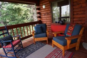 a porch of a cabin with chairs and a table at Beautiful Mountain Cabin near Tetons Yellowstone in Dubois